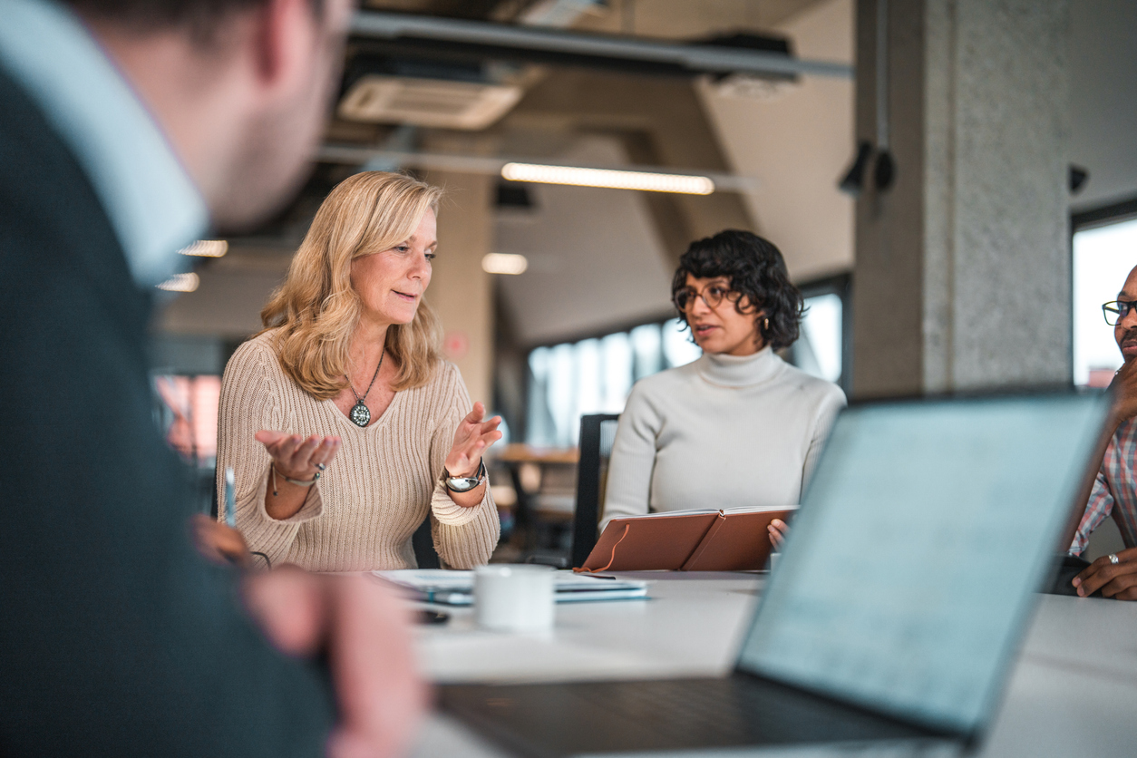 Man Observing Female Colleagues Discussing Ideas